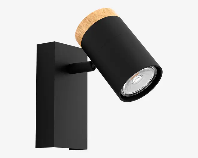 Et moderne vægmonteret spotlys med en mat sort cylindrisk lampe og en naturlig trædetalje øverst. Lampen er fastgjort til en rektangulær sort base og har et justerbart hoved, så lyset kan rettes efter behov. Designet er minimalistisk og moderne, velegnet til forskellige indretninger.
