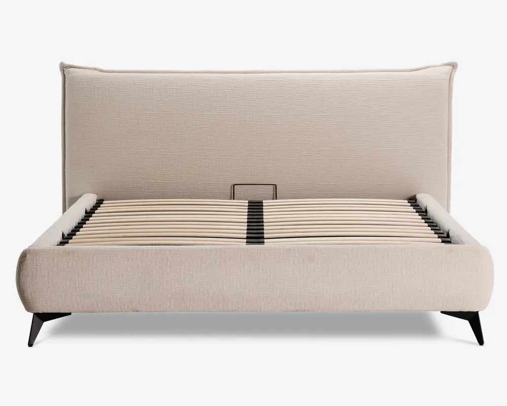 En moderne sengegavl med en høj, polstret hovedgavl i lysebeige stof. Rammen har rene, lige linjer og en blød, tekstureret overflade. Bunden består af jævnt fordelte lameller i træ til støtte af madrassen, og benene er skrå og mørke, hvilket giver et solidt fundament. Designet er minimalistisk og moderne, velegnet til forskellige soveværelsesstile.