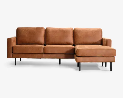 Tanfarvet lædersofa med tre ryghynder, tre sædehynder, slanke sorte metalben og en chaiselong på højre side.