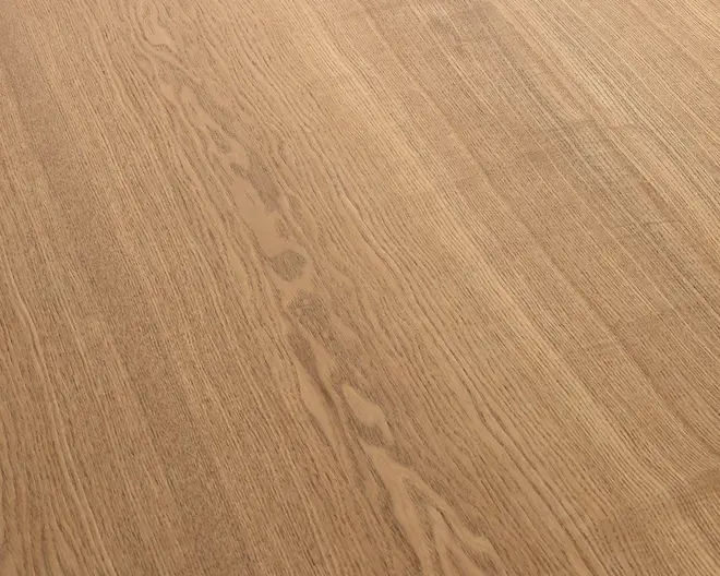 Nærbillede af en lys egetræsoverflade med varme beige-brune toner og tydelige naturlige åretegninger, der løber diagonalt.