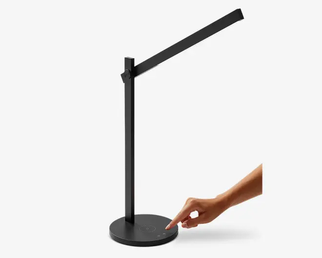 Elegant, moderne skrivebordslampe med mat sort finish og justerbar arm, så lyset kan rettes efter behov. Lampen har et touch-følsomt kontrolpanel på den runde fod, hvilket gør det nemt at justere lysstyrken. LED-lysbåndet giver jævn belysning, og det minimalistiske design passer godt til nutidige arbejdsområder.