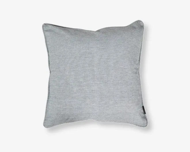 Rektangulær pude med betræk i tynde, horisontale sorte og hvide striber. Stoffet ser blødt og glat ud med pænt syede kanter og et lille stofmærke i den ene side. Puden fremstår fyldig og støttende, velegnet til brug på sofa eller seng.