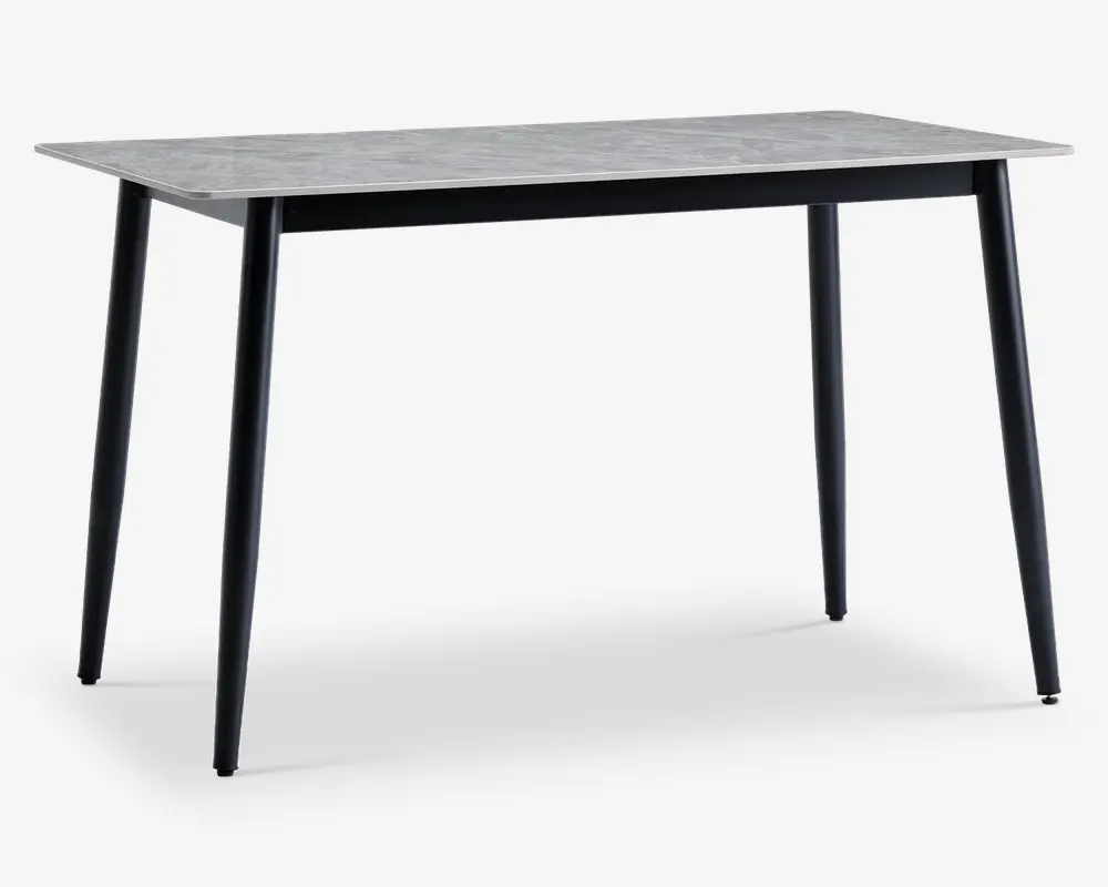Rektangulært bord med en lysegrå bordplade med marmoreffekt og fire slanke, sorte metalben, der er let skråtstillede. Designet er minimalistisk og moderne med en glat overflade og rene linjer, velegnet til spise- eller kontorbrug.