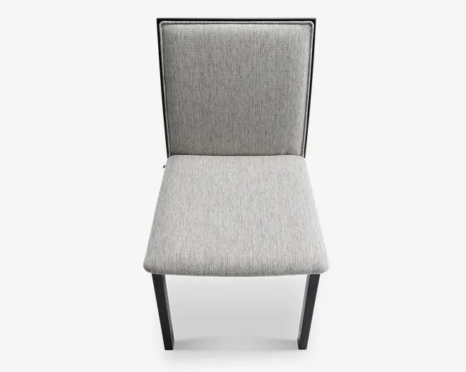 Stol med rektangulær ryg og sæde, begge polstret med et lysegråt tekstil med struktur. Stolen har et enkelt, moderne design med lige, sorte ben og en slank sort ramme omkring ryglænet. Sædet og ryglænet ser polstrede ud for ekstra komfort.