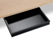 Et nærbillede af en elegant, sort underskuffe monteret under en bordplade i lyst træ. Skuffen er rektangulær, har en glat, mat overflade og er vist helt udtrukket, hvilket giver god opbevaringsplads til små kontorartikler eller personlige ejendele. Designet er minimalistisk og moderne og passer diskret sammen med bordet.