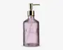 Høj, rillet glasdispenser med let lilla nuance, udstyret med en guldfarvet pumpe og ordet 'SOAP' præget på forsiden. Flasken har et vintage-inspireret design med lodrette riller, der giver ekstra greb og stil.