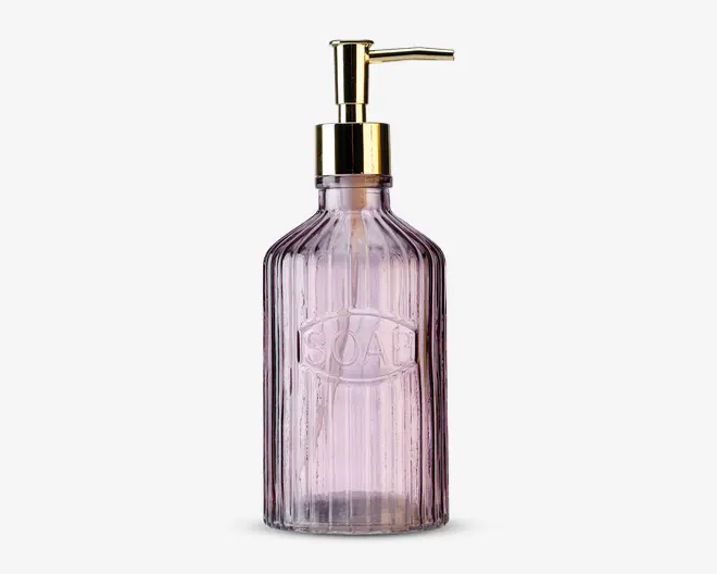Høj, rillet glasdispenser med let lilla nuance, udstyret med en guldfarvet pumpe og ordet 'SOAP' præget på forsiden. Flasken har et vintage-inspireret design med lodrette riller, der giver ekstra greb og stil.