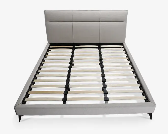 Moderne sengegavl med lysegråt polstret hovedgærde, der har tre store rektangulære paneler. Rammen har en lav profil med matchende gråt stof på siderne og fodenden. Bunden består af jævnt fordelte lameller i træ, som understøttes af en sort metalstruktur, hvilket gør det muligt at bruge sengen uden boxmadras. Sengen står på korte, skrå sorte ben.