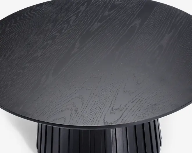 Rund bordplade med mørk træstruktur og glat overflade. Basen har lodrette riller, hvilket giver et moderne og tekstureret udtryk til designet.