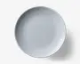 Rund hvid tallerken med et diskret tekstureret mønster af lodrette riller langs kanten. Midten er glat og enkel, hvilket giver et minimalistisk og elegant udtryk. Fremstillet af blankt keramisk materiale.