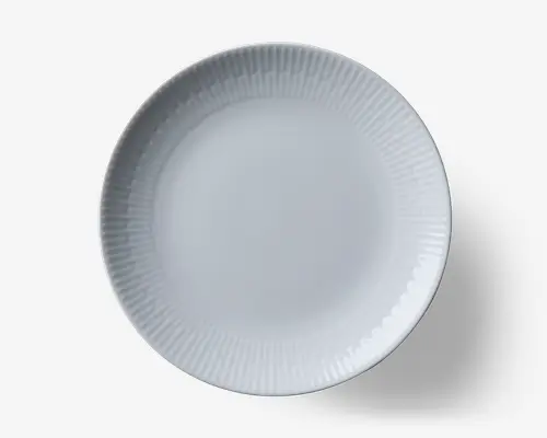 Rund hvid tallerken med et diskret tekstureret mønster af lodrette riller langs kanten. Midten er glat og enkel, hvilket giver et minimalistisk og elegant udtryk. Fremstillet af blankt keramisk materiale.