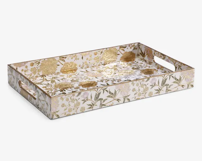 Rektangulær bakke med forhøjede sider og udskårne håndtag i hver ende. Overfladen har et elegant blomsterdesign med gyldne detaljer, herunder metalliske guldblomster og blade på en hvid baggrund. Designet er detaljeret og luksuriøst, hvilket giver bakken et dekorativt og stilfuldt udseende, velegnet til servering eller udstilling.