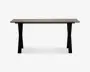 Rektangulært bord med en glat, lys bordplade og fire solide, let udadbuede sorte ben. Designet er minimalistisk og moderne med rene linjer og en rummelig overflade, der egner sig til både spisning og arbejde.