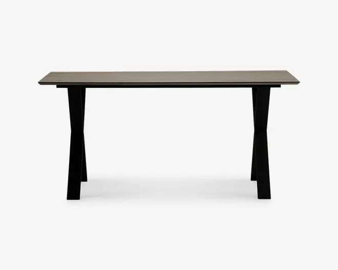 Rektangulært bord med en glat, lys bordplade og fire solide, let udadbuede sorte ben. Designet er minimalistisk og moderne med rene linjer og en rummelig overflade, der egner sig til både spisning og arbejde.