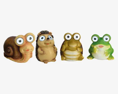 Sæt med fire finurlige dyrefigurer med store, udtryksfulde øjne. Sættet består af en brun snegl med spiralformet hus, et beige pindsvin med teksturerede pigge, en gulbrun frø med rund mave og en grøn og hvid frø med bred mund. Hver figur har et legende, tegneserieagtigt udtryk og glatte, afrundede former, hvilket gør dem velegnede til dekoration eller leg.
