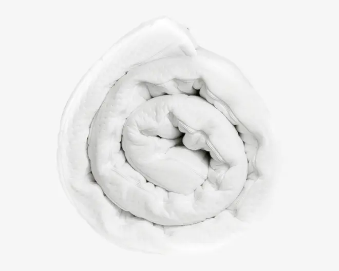 En sammenrullet, luftig hvid dyne med en glat, quiltet overflade. Stoffet ser blødt og behageligt ud, og dynen virker tyk og velisoleret, ideel til varme og komfort.