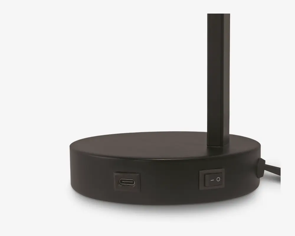 Nærbillede af en rund, mat sort base med en lodret stang. Basen har en USB-C-port og en tænd/sluk-knap på siden samt en strømkabel, der går ud bagpå. Designet er moderne og minimalistisk.