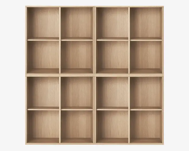 En stor reol i lyst træ med naturlig træstruktur. Reolen er opdelt i seksten lige store, rektangulære rum, arrangeret i et 4 x 4 gitter. Hvert rum har en åben front og ingen synlig bagplade, hvilket giver god plads til opbevaring eller udstilling. Kanterne er lige, og designet er minimalistisk og moderne.