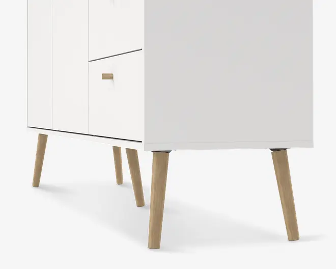 Nærbillede af den nederste del af et møbel med glat, hvid overflade. Møblet har skråtstillede ben i lyst træ og minimalistiske greb på skuffer og låger, hvilket giver et moderne, skandinavisk udtryk.