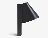 En moderne vægmonteret lampe med mat sort finish. Lampen har en konisk skærm, der leder lyset nedad, og er fastgjort til en rektangulær, lodret base. Designet er minimalistisk og stilrent, velegnet til moderne indretning.