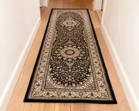 En lang, rektangulær løber med et traditionelt persisk-inspireret design. Tæppet har en mørk bundfarve med indviklede blomster- og rankemønstre i beige, creme og bordeaux nuancer. Der er to store medaljonmotiver placeret langs midten, og kanten er dekoreret med detaljerede, gentagne blomstermønstre i lyse farver. Tæppet har en lav luv og ser ud til at være lavet af et tæt vævet materiale.