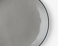 Et nærbillede af et enkelt, rundt, tyndt og let gennemsigtigt fladbrød med en glat overflade og lys beige farve. Kanterne er en smule ujævne, og fladbrødet ser blødt og fleksibelt ud.