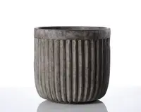 En cylindrisk beholder lavet af mørkegrå beton med mat overflade. Ydersiden har jævnt fordelte lodrette riller, der løber fra top til bund og giver en rillet tekstur. Kanten er glat og en smule tykkere end selve kroppen, og det samlede design er moderne og minimalistisk.