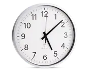 Rund vægur med hvid urskive, sorte time- og minutvisere samt en tynd sort sekundviser. Uret har store, tydelige sorte arabiske tal for hver time og minutmarkeringer langs kanten. Det har en enkel, moderne sølvramme og klart glas foran. Klokken viser 5:08:00. Under midten er der et lille symbol og tekst, der indikerer, at uret er radiostyret for præcis tidsangivelse.