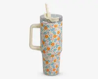 Høj, cylindrisk termokop med stort cremefarvet håndtag og gennemsigtigt plastlåg med opklappeligt sugerør. Ydersiden er dekoreret med et farverigt blomstermønster med gule og orange blomster samt blå blade på hvid baggrund.