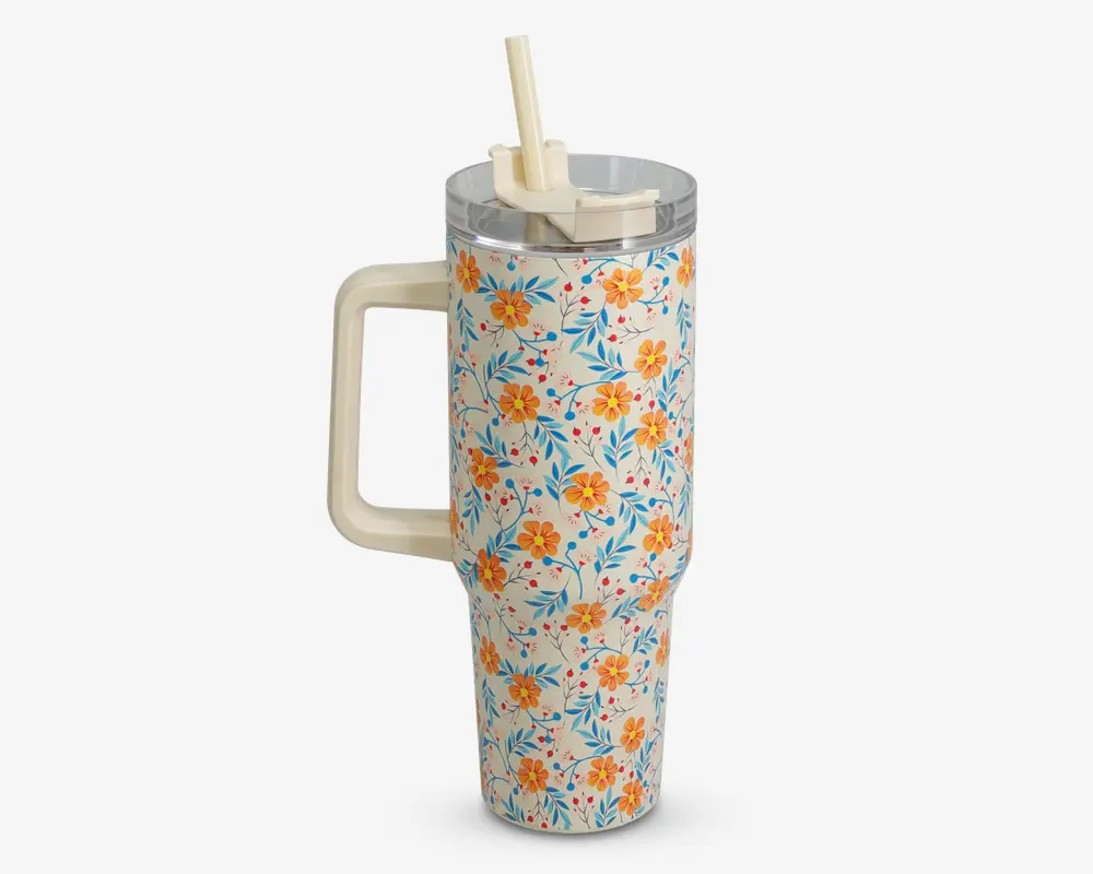 Høj, cylindrisk termokop med stort cremefarvet håndtag og gennemsigtigt plastlåg med opklappeligt sugerør. Ydersiden er dekoreret med et farverigt blomstermønster med gule og orange blomster samt blå blade på hvid baggrund.