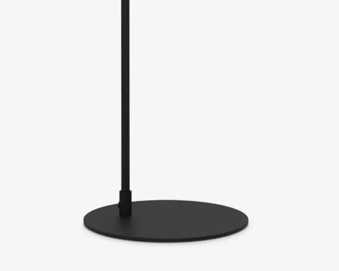 Billedet viser en rund, flad base med mat sort finish, der understøtter en slank, lodret stang. Designet er minimalistisk og moderne med rene linjer og et robust udseende. Basen er bred og flad, hvilket giver stabilitet til stangen.