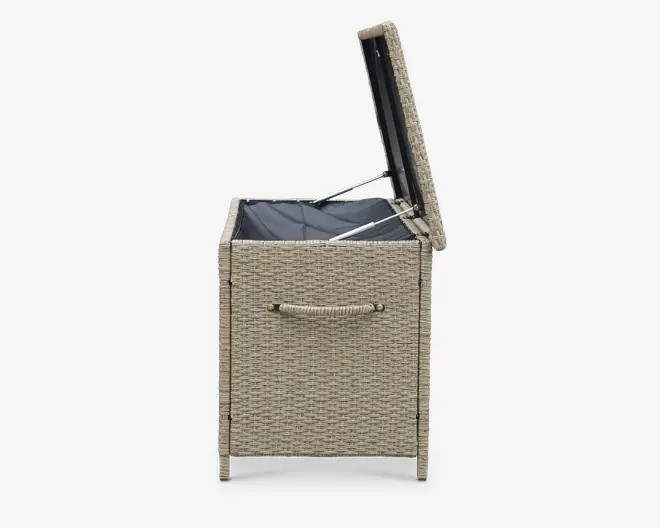 Sidevisning af en rektangulær opbevaringskasse med flettet rattan-lignende ydre i en lys beige farve. Låget er åbent og afslører en sort, vandtæt inderfor. Kassen har et solidt rebhåndtag på siden for nem transport, og låget holdes åbent af metalhængsler og en støtte.