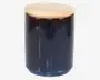 En cylindrisk, mørkeblå glasbeholder med glat overflade og et fladt, rundt låg af lyst træ. Låget sidder tæt og giver en lufttæt lukning. Beholderen har et minimalistisk design, der passer godt til moderne køkkener eller opbevaringsområder.