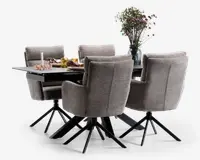 Et moderne spisesæt bestående af et rektangulært sort bord med mat overflade og seks polstrede stole. Stolene er betrukket med et blødt, lysegråt stof, har høje rygge med diskrete horisontale syninger, polstrede armlæn og står på sorte metalstel med fire ben og drejefunktion. Bordet er dækket med dekorative elementer såsom en vase med friske blomster, et stearinlys, glas og servietter, hvilket skaber en indbydende og elegant spiseatmosfære.