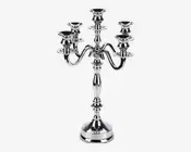 Elegant fem-armet lysestage lavet af poleret sølvmetal. Har en central søjle med dekorative detaljer og fem buede arme, der hver ender i en rund lyseholder. Basen er bred og stabil, hvilket giver god støtte. Det samlede design er klassisk og egnet til formelle omgivelser eller dekorativ brug.