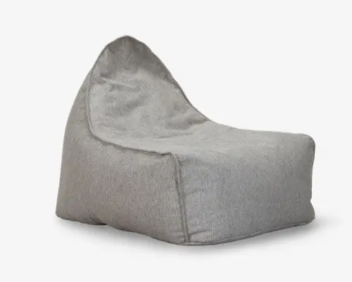 Lys grå sækkestol med en struktureret, opretstående ryg og en bred, dyb siddeflade. Stoffet ser blødt og tekstureret ud, og syningerne er synlige langs kanterne, hvilket giver et afslappet og uformelt udtryk. Basen er flad og stabil, hvilket gør stolen velegnet til afslapning eller uformel siddeplads.