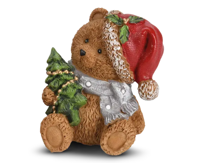 En dekorativ bjørnefigur med tekstureret brun pels, iført en rød nissehue pyntet med kristtornblade og bær samt et sølvfarvet tørklæde med hvide prikker. Bjørnen holder et lille grønt juletræ dekoreret med guldfarvede perler. Figuren har et sødt, venligt udtryk og detaljerede træk, hvilket gør den velegnet som julepynt.