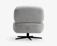 En moderne stol med tyk, blød ryg- og sædehynde betrukket med lysegråt, tekstureret stof. Stolen har et afrundet, rummeligt design for ekstra komfort og står på en sort metalfod med fire ben, der giver stabilitet og mulighed for at dreje.