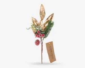 Dekorativt arrangement med tre store blade i metallisk guld, en klase af frostede røde bær, en grangren og grønt løv. Stilken er brun og har et mærkat af kraftpapir med teksten 'CHRISTMAS'. Udtrykket er festligt og elegant, velegnet til juledekoration.