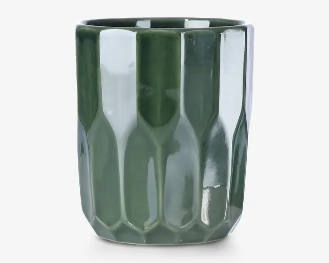 En blank, mørkegrøn keramisk beholder med et facetmønstret, geometrisk overfladedesign. Siderne har lodrette, aflange paneler, der giver et moderne og tekstureret udtryk. Kanten er glat og let afrundet, og formen er cylindrisk med en stabil, flad bund.