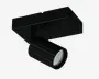 Justerbar spotlampe med mat sort finish, der har et cylindrisk lampehoved med diskrete lodrette riller for ekstra struktur. Lampehovedet indeholder flere synlige LED-dioder arrangeret i en cirkel, hvilket giver fokuseret belysning. Lampen er monteret på en rektangulær base med rene, moderne linjer, velegnet til montering i loft eller på væg.