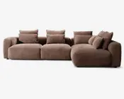 Moderne hjørnesofa med chaiselong til højre, betrukket med tekstureret brunt stof. Sofaen har brede, afrundede armlæn og bløde, fyldige sæde- og ryghynder for ekstra komfort. Inkluderer flere matchende pyntepuder for ekstra støtte og et hyggeligt udtryk. Designet er lavt og har et moderne, indbydende look.