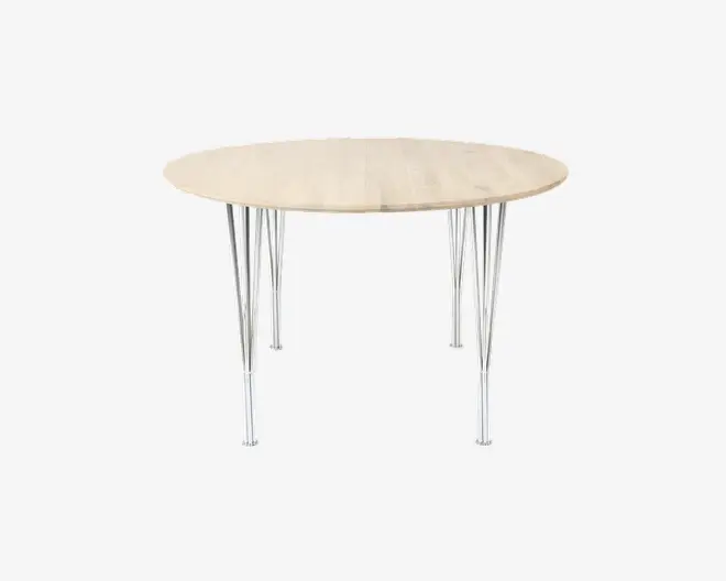 Rundt bord med en bordplade i lyst træ og slanke ben i krommetal. Bordpladen har en glat overflade, og benene er tynde og vinklet, hvilket giver bordet et moderne og minimalistisk udtryk.