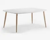 Rektangulært bord med en glat, mat hvid bordplade og afrundede hjørner. Bordet har fire let skråtstillede, cylindriske ben i lyst træ med naturlig finish. Designet er minimalistisk og moderne, velegnet til spise- eller arbejdsbrug.