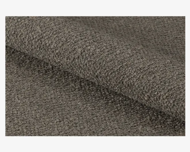 Nærbillede af et tekstiler med en tæt vævet, løkket overflade i en dæmpet brungrå farve, som giver et blødt og nubret udtryk. Materialet ser tykt og slidstærkt ud, velegnet til polstring eller kraftig brug.