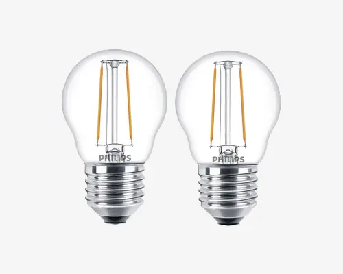 Sæt med to LED-pærer i klart glas med synlige gule filamenter, standard skruefatning og kompakt rund form. Pærerne har et moderne, energieffektivt design og passer til forskellige lamper. Mærkenavnet er trykt på metalbasen.