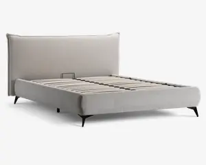 Moderne sengegavl med højt, polstret hovedgærde i lysebeige stof. Rammen har rene linjer og et minimalistisk design med let skråtstillede sorte ben. Bunden består af jævnt fordelte trælister til madrasstøtte, og siderne er også polstret i samme stof som hovedgærdet.