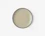 Rund tallerken med en glat, blank beige overflade og en tynd, mørk kant. Designet er minimalistisk og moderne med en let hævet kant, der holder maden på plads.