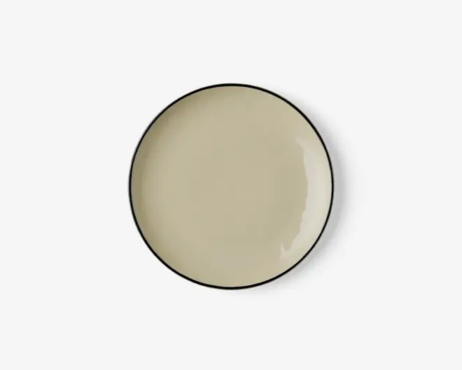 Rund tallerken med en glat, blank beige overflade og en tynd, mørk kant. Designet er minimalistisk og moderne med en let hævet kant, der holder maden på plads.