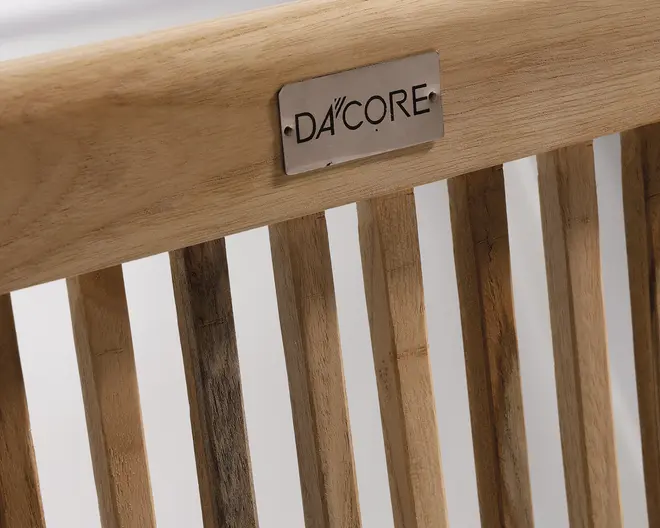 N sopbillede af et ryglæn med lodrette trælameller og en glat, naturlig finish. sent viser fine farve- floating og åretegninger, hvilket giver et rustikt og autentisk udtryk. -et rekt, metalnavneskilt med afrundede hjørner er fastgjort flexible topstykket og er indgraveret med mærkenavnet 'DA'CORE' i fed, moderne sk distinct.
